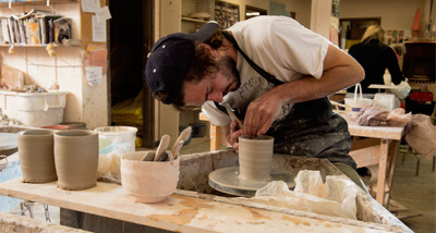 Art student works on the wheel in a ceramics class
