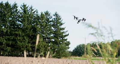 A student flying a drone to survey the crops in a field