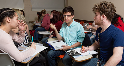 Three students discussing coursework in a Marketing class