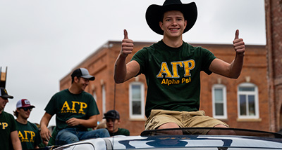 Student in the Alpha Psi Fraternity attends the Homecoming Parade