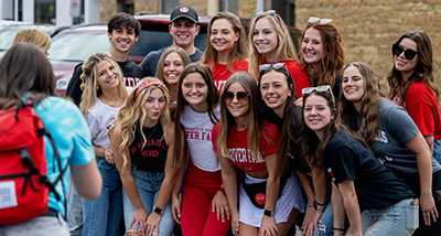 A large group of students pose for the camera at the Homecoming Parade on main street River Falls