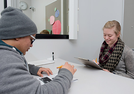 Communication student interviews another student during a hearing clinic