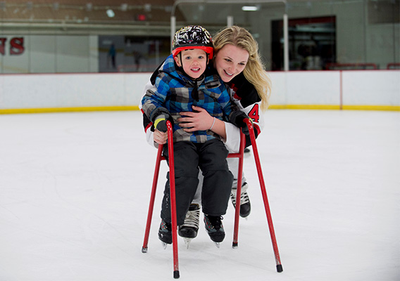 UWRF Hockey Player helps child learn how to skate