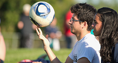 Student balances a soccer ball on their fingertips