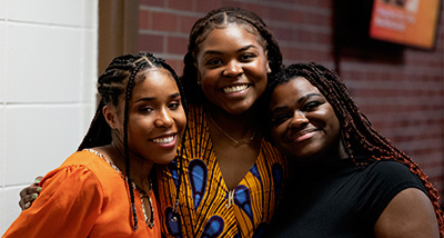 Three students attend an Africa Night celebration in the University Center