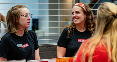Two students speak to another at the "get to know campus" event